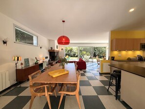 A modern kitchen with a dining area, a red pendant light, and a view to the outdoors. - Charming villa at Cap Ferret Point - 8 guests (Lège-Cap-Ferret-Le Cap Ferret)