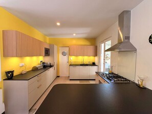 A modern kitchen with wooden cabinets, a black countertop, and a stainless steel range hood. - Charming villa at Cap Ferret Point - 8 guests (Lège-Cap-Ferret-Le Cap Ferret)