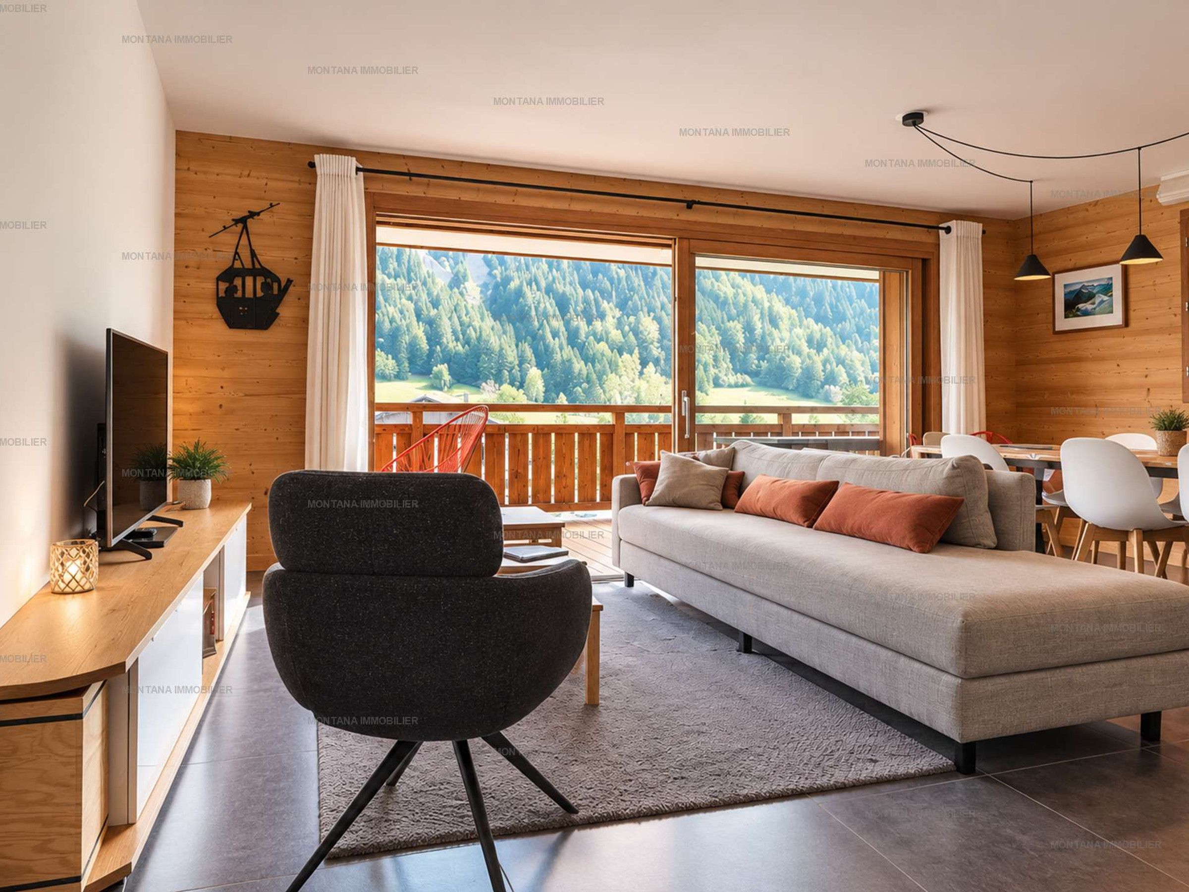 Una sala moderna con sofá, sillón, televisor y un amplio ventanal con vista al bosque.