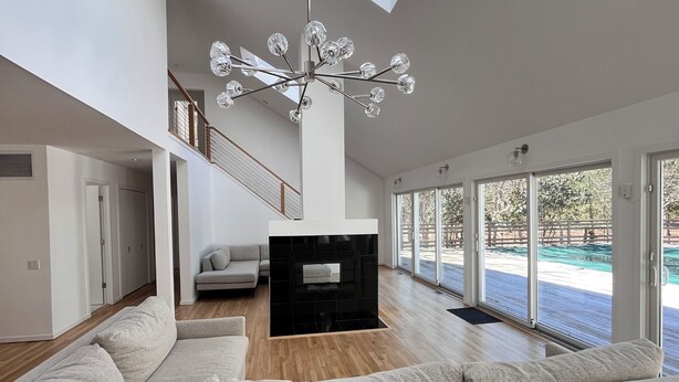 Una sala de estar moderna con un sofá modular, una chimenea y un tragaluz.