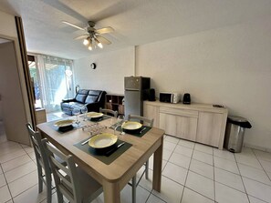A compact living space with a dining area, kitchenette, and a ceiling fan. - Apartment with AC and parking - 3 guests (Saint-Cyprien)