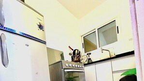 Cucina compatta con frigorifero, forno e microonde.