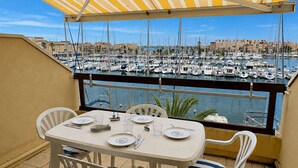 A terrace with a table set for dining, overlooking a marina with numerous boats. - Studio with terrace port view - 4 guests (Gruissan)