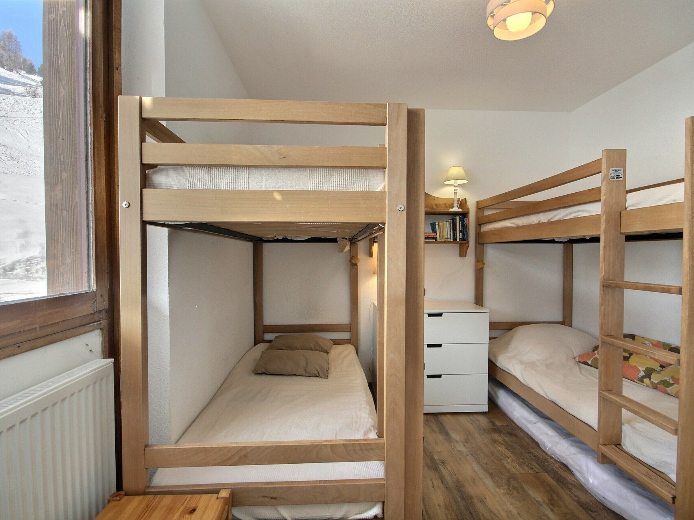 Camera con un letto a castello, un comodino e una lampada.