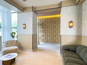 A modern hotel lobby with a sofa, armchair, and a small table. - ®{Niza~City~Tower} @DowntownSD +Pool+Gym+Balcony (Santo Domingo)