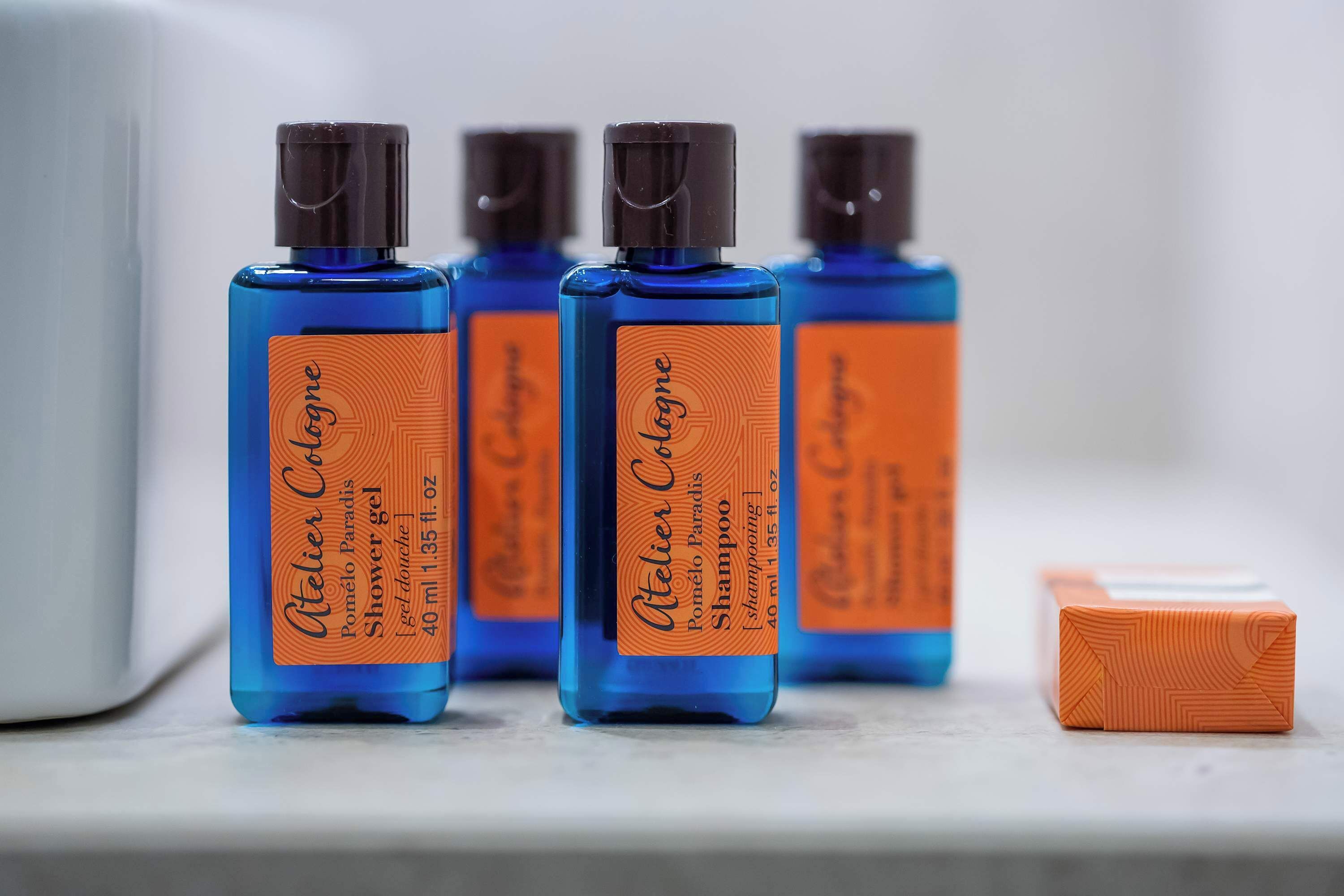 Quatre flacons de gel douche Paradox d’Atelier Cologne et un savon.