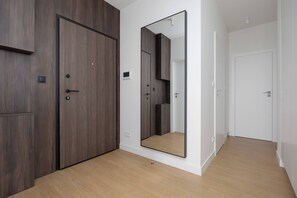 Una habitación con un armario de madera, un espejo grande y una puerta blanca.