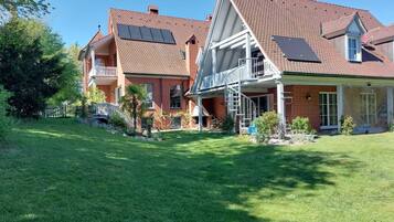 Ein zweistöckiges Haus mit überdachter Veranda, Solaranlage und gepflegtem Rasen.