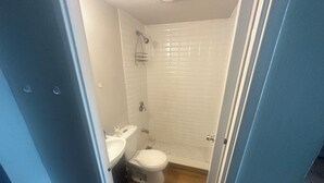 Kylpyhuone, jossa on wc, pesuallas ja suihku.