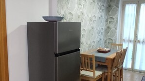 A kitchen with a refrigerator, dining table, chairs, and a patterned wallpaper. - Eve's House. Up to 4 guests. Opposite the subway station (Roma)