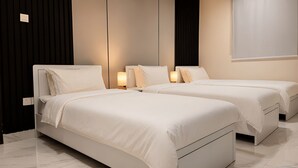 A hotel room with two beds, a dark wall, and a light-colored floor. - Apartment in Makkah (Makkah)