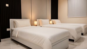A hotel room with two beds, a dark wall, and a light-colored floor. - Apartment in Makkah (Makkah)