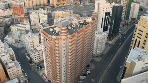 A high-rise building with a unique architectural design, surrounded by other buildings and roads. - Apartment in Makkah (Makkah)
