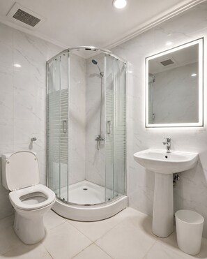 A modern bathroom with a glass-enclosed shower, a toilet, a sink, and a mirror. - Apartment in Makkah (Makkah)