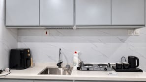 Una cocina moderna con estufa integrada, un lavamanos y un tostador.