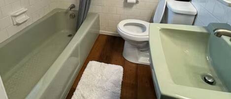 Un baño con bañera, inodoro y lavabo.