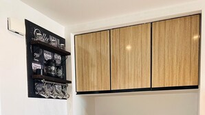 A compact kitchen with a black and white color scheme, featuring a built-in stove, a coffee maker, and a wine rack above the counter. - Hacienda Bay Lagoon Cabin | Beachfront Escape (Sidi abdelrahman , al Alamein)