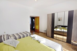 Une chambre à coucher comprenant un lit, une armoire et une porte donnant sur une autre pièce.