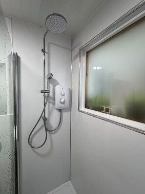 A shower with a handheld hose, a control unit, and a window with a view. - Two Miles From Town (Inverness)