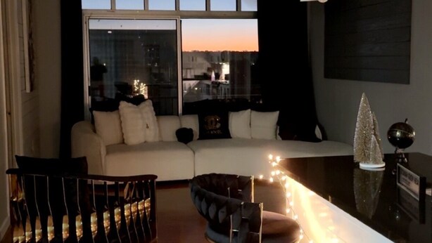 A modern living room with a sofa, chairs, a dining table, and a view of the city through large windows. - Cozy 2-bedroom condo with AC in lovely Atlanta Buckhead (Atlanta)