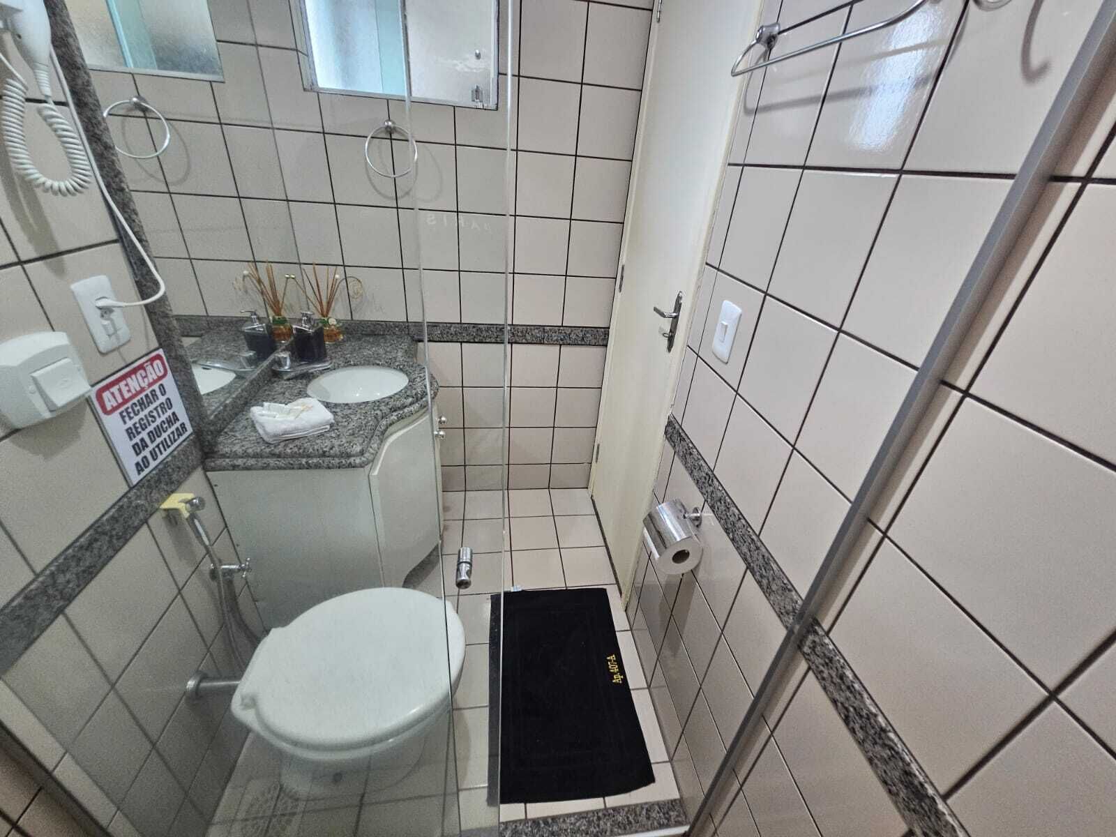 Une petite salle de bain avec des toilettes, un lavabo et une douche.