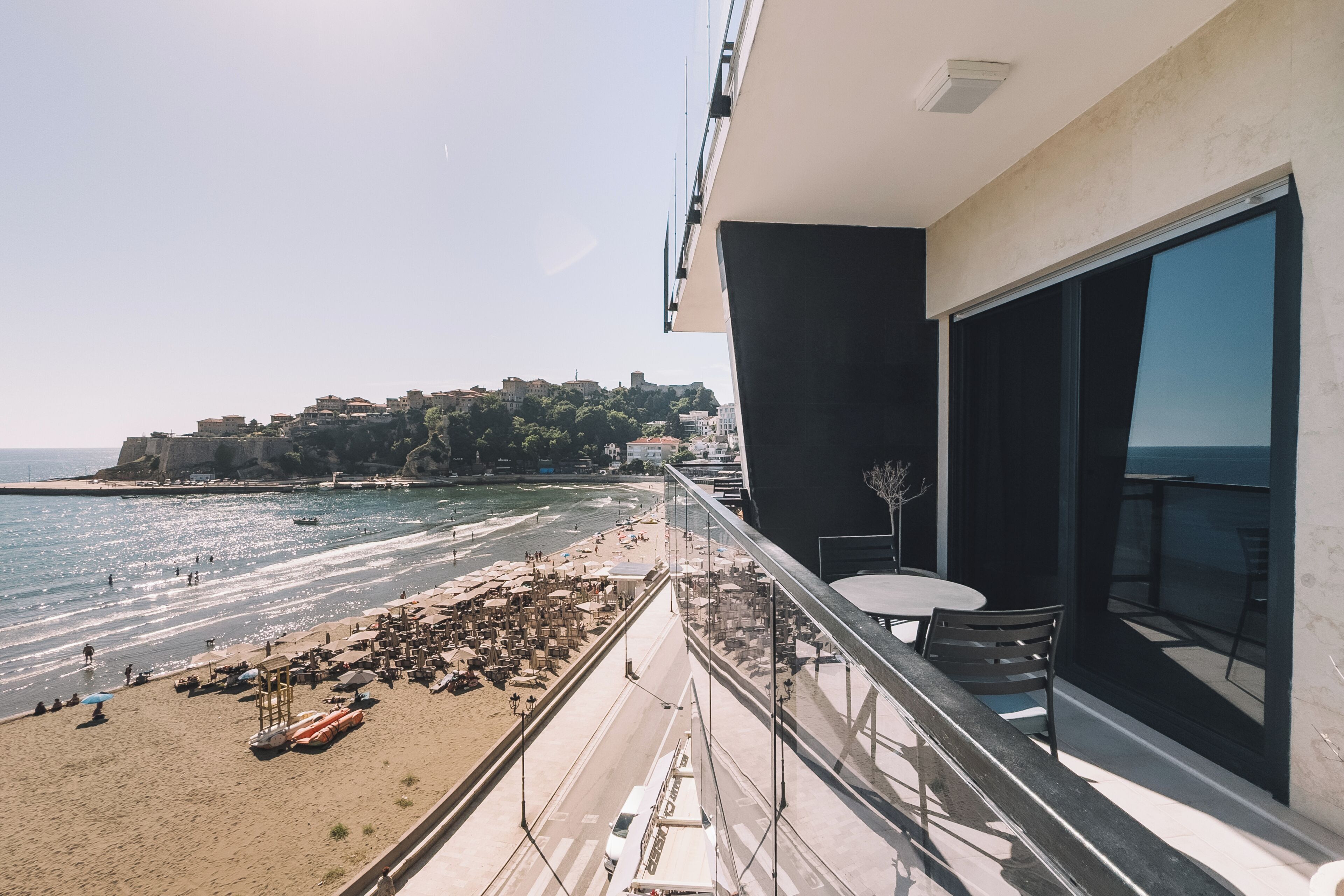 Un balcon avec vue sur une plage et sur le paysage urbain.