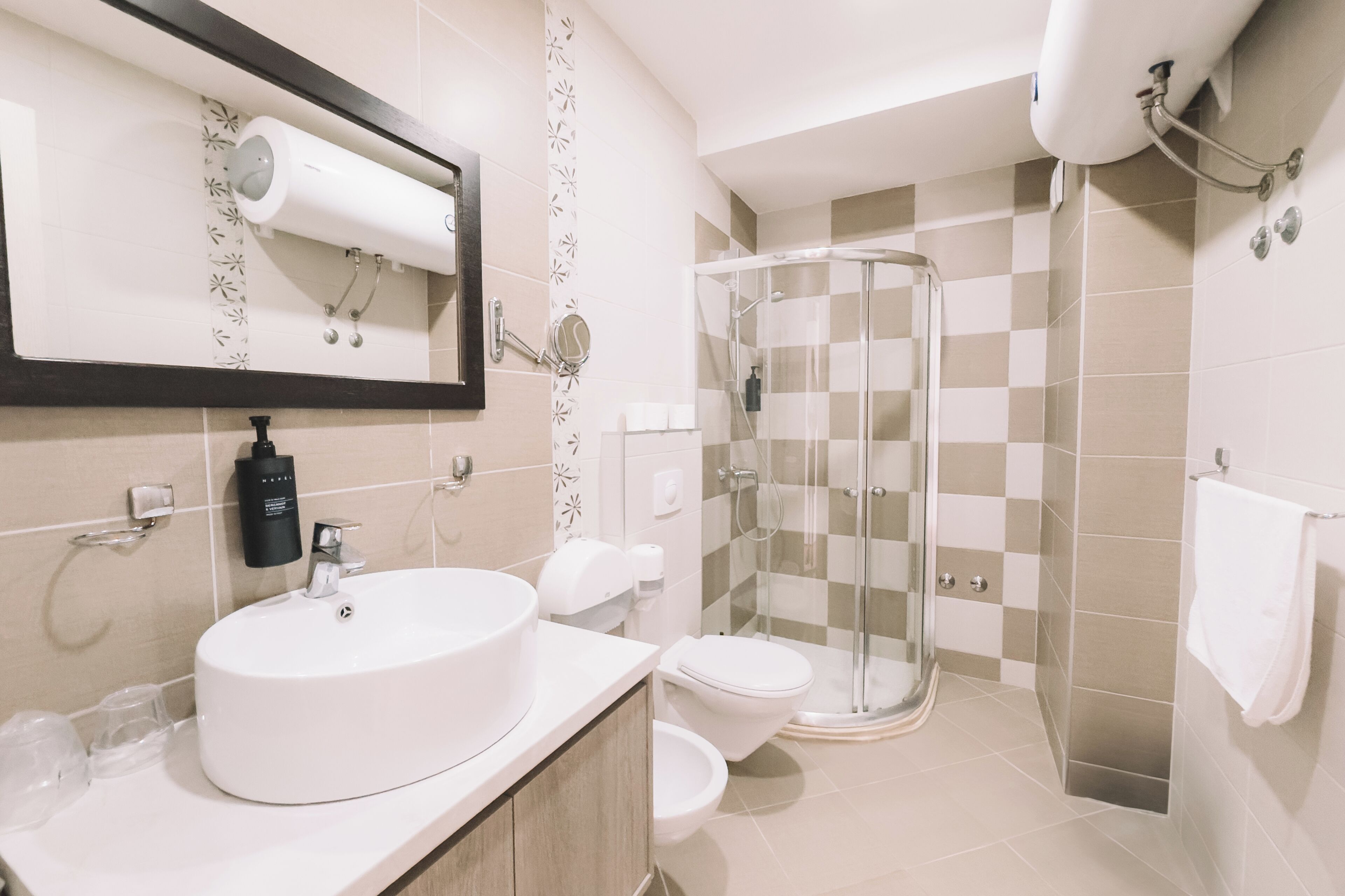 A bathroom with a sink, toilet, and glass shower enclosure.