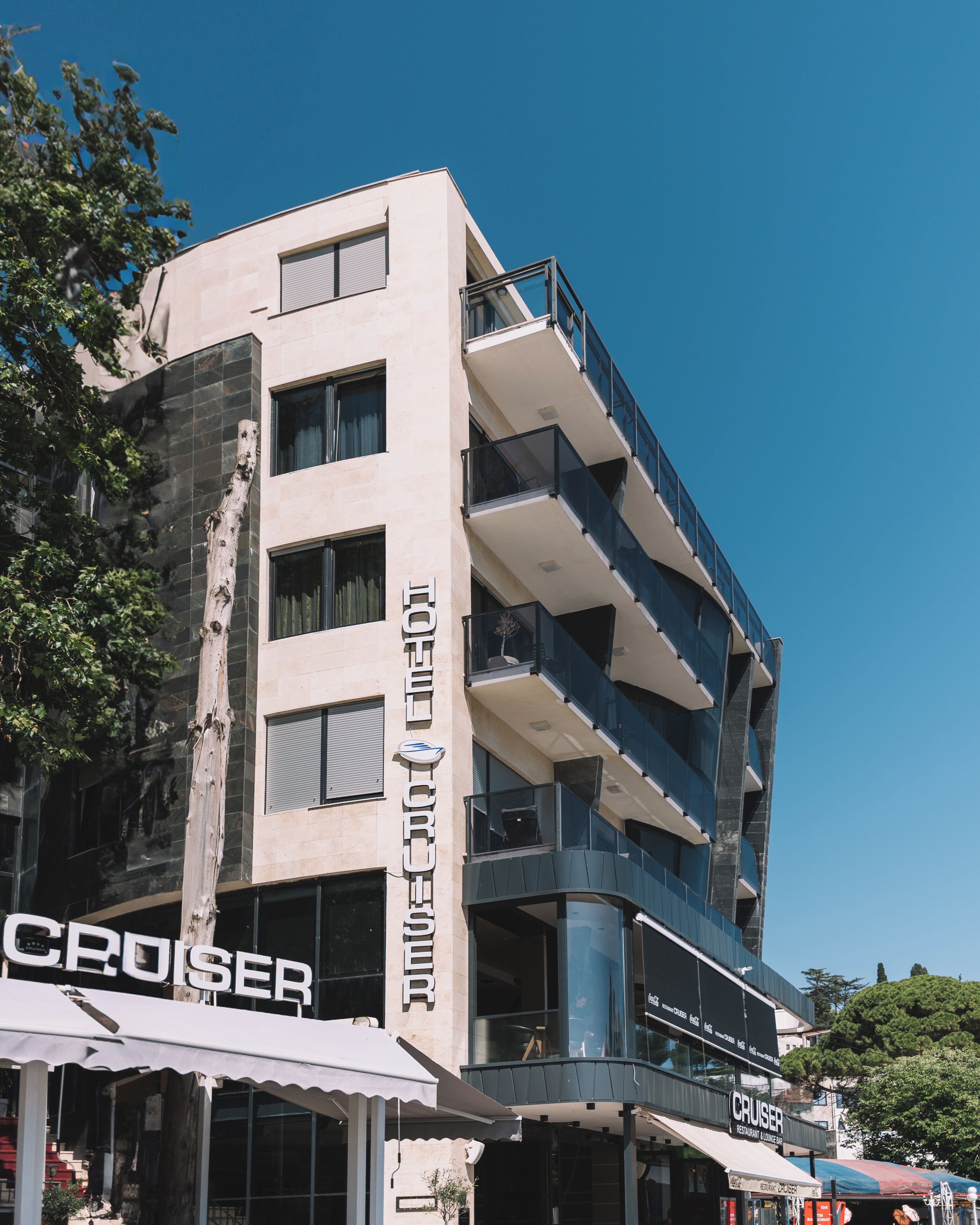 A multi-story building with a modern architectural design, featuring balconies and large windows.