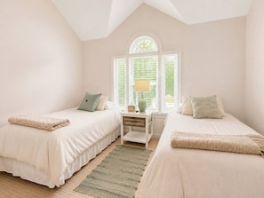 A bedroom with two beds, a nightstand, a lamp, and a window with blinds. - Relaxing Backyard • BBQ • 5BR • Pet Friendly (Charlotte)