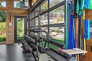 Ein Fitnessraum mit einer Gewichtbank, Kurzhanteln und Widerstandsbändern.