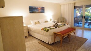 Une chambre à coucher comprenant un lit, une table de chevet, une chaise et donnant sur l’extérieur.