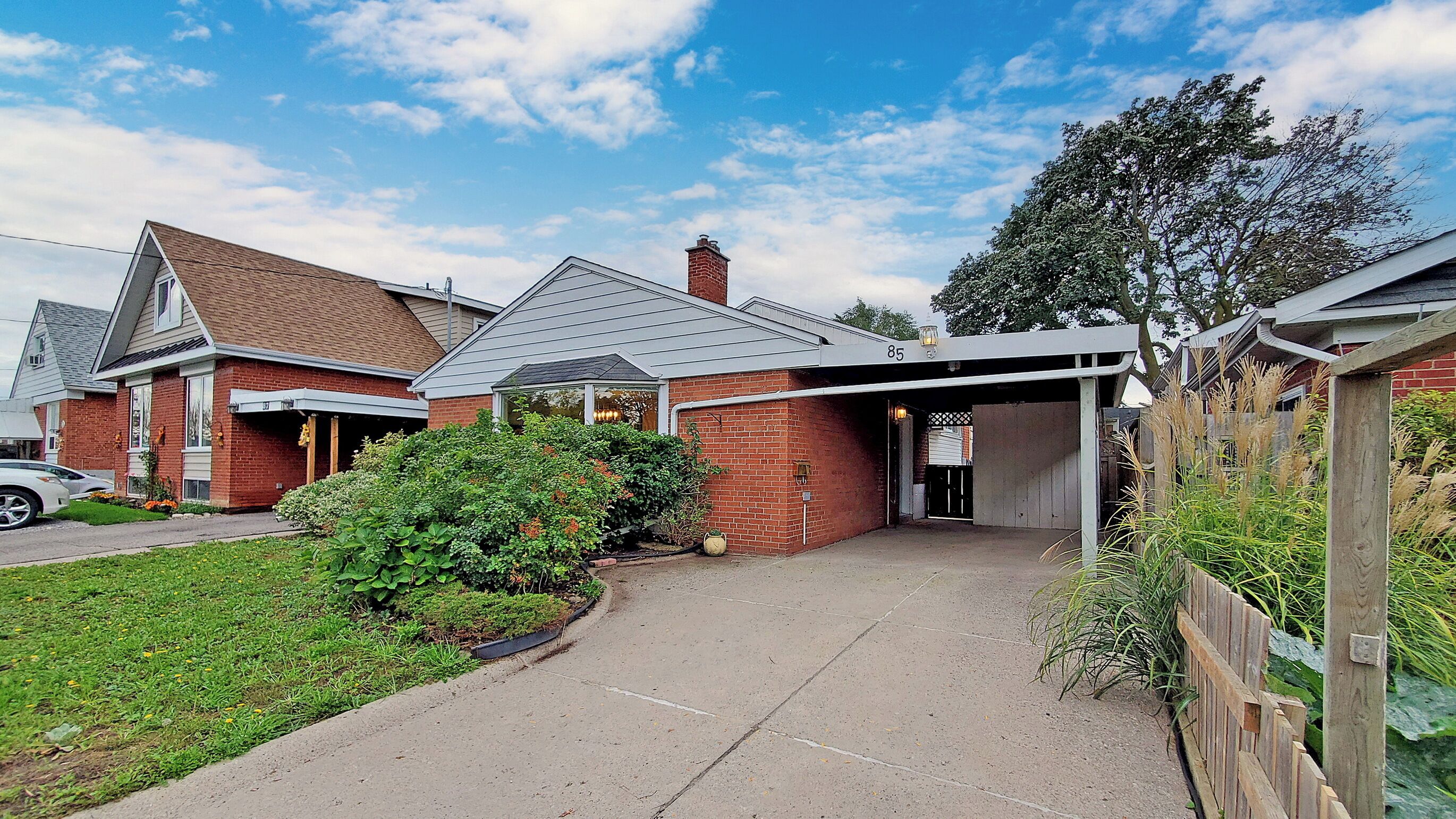 A residential house with a garage, a driveway, and a well-maintained garden.