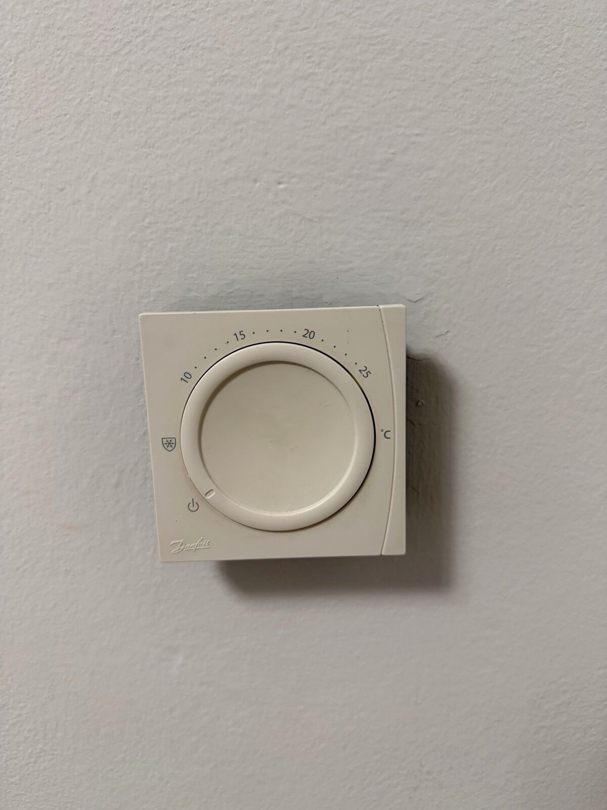 A thermostat mounted on a wall.