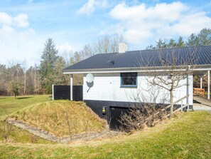 A single-story house with a satellite dish, a small window, and a covered porch. - 7 Person Holiday Home in Skals (Skals)