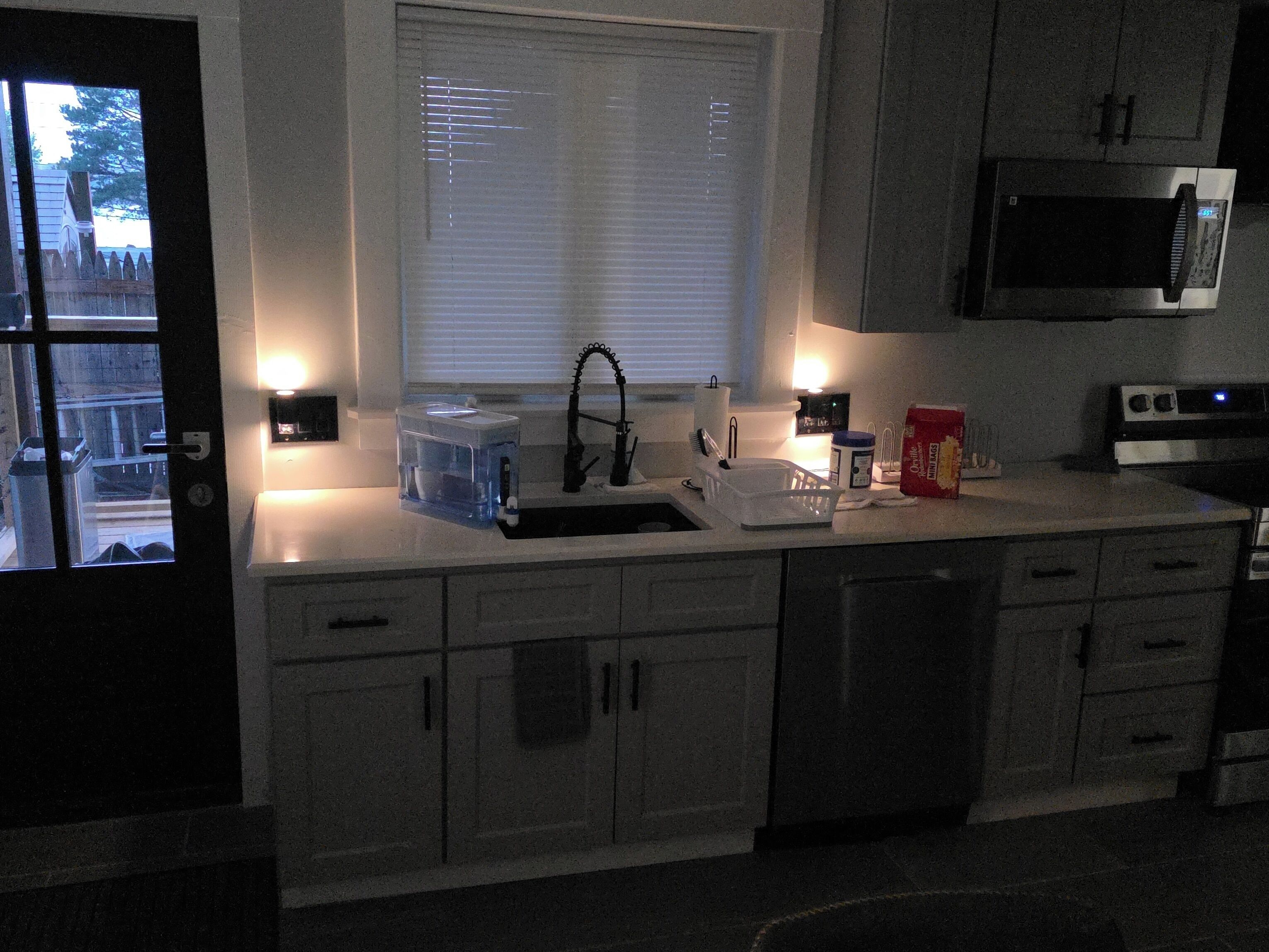 A kitchen with a microwave, toaster, and sink.
