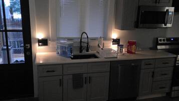 A kitchen with a microwave, toaster, and sink.