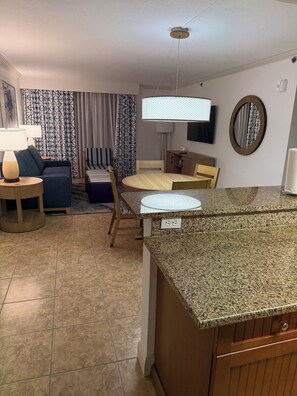 Ein modernes Wohnzimmer mit Sofa, Esstisch und Küchenzeile mit Granit Arbeitsplatten.