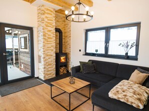 Ein Wohnzimmer mit Steinsandsteinwand, Kamin, Sofa, Couchtisch und Fenster.