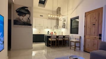 Una sala moderna con un sofá, una mesa de centro y un comedor con sillas y una mesa.