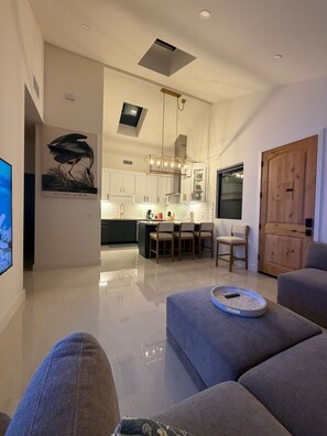 Ein modernes Wohnzimmer mit einer Couch, einem Couchtisch und einem Essbereich mit Stühlen und Tisch.