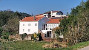 A white building with a red roof, surrounded by greenery and trees. - Quinta Farm stay (Lousã)