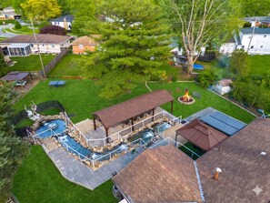 Ein privater Garten mit Schwimmbad, Whirlpool, Feuerstelle und überdachter Terrasse.