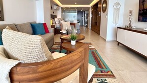Ein modernes Wohnzimmer mit Sofa, Couchtisch und Dekorationselementen.