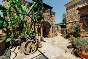 A courtyard with stone buildings, a bicycle, and potted plants.