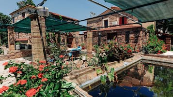 A courtyard with a pool, stone buildings, and outdoor seating.