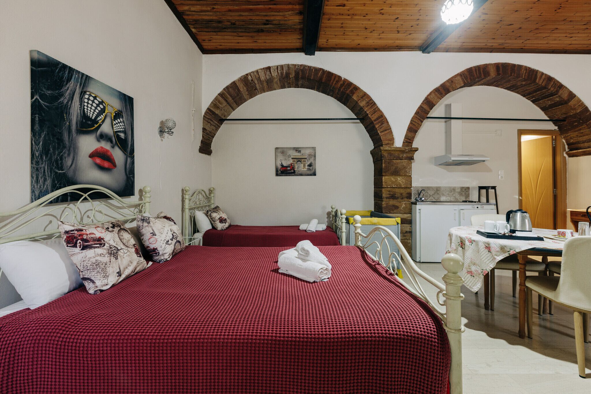 Een kamer met een bed, een tafel en een kitchenette.