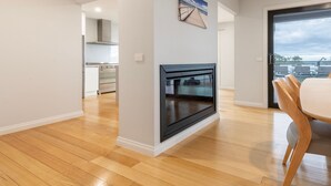 Una cocina moderna con horno empotrado, un comedor con mesa y sillas, y vistas a través de un ventanal.