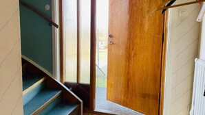 Eine Treppe, die zu einer Tür mit Knauf und einer Fußmatte führt.