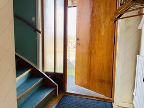 Eine Treppe, die zu einer Tür mit Knauf und einer Fußmatte führt.