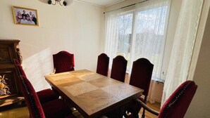 Ein Esszimmer mit einem Holztisch und sechs rot gepolsterten Stühlen.